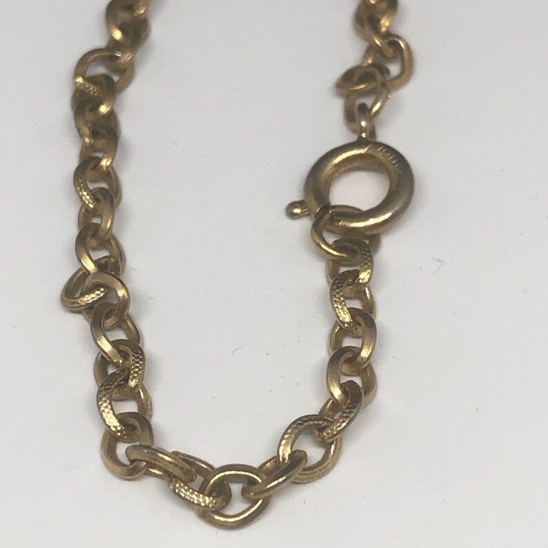 May include: Gold chain necklace with a lobster clasp closure.