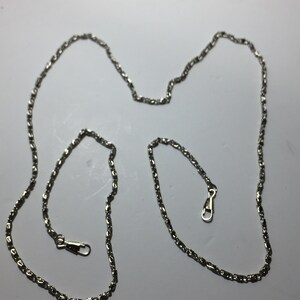 Bolso de mano con cadena larga y ornamentada, correa de mano, asa plateada