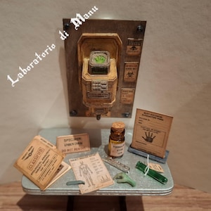 Op de afbeelding: Een miniatuur wetenschappelijke laboratoriumset met een aan de muur gemonteerde console met een gloeiend groen centrum, een klein amberkleurig flesje met het label Formaldehyde 10%, een biologisch onderzoeksformulier, een geheim analyserapport en kleine groene specimens.
