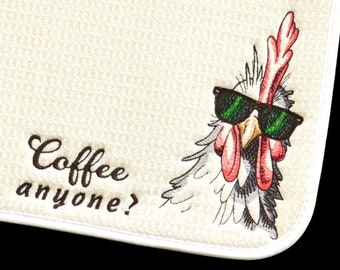 May include: A cream-coloured waffle-weave kitchen towel featuring an embroidered graphic of a chicken wearing green-tinted sunglasses. The text "Coffee anyone?" is embroidered in dark brown script lettering to the left of the chicken illustration.