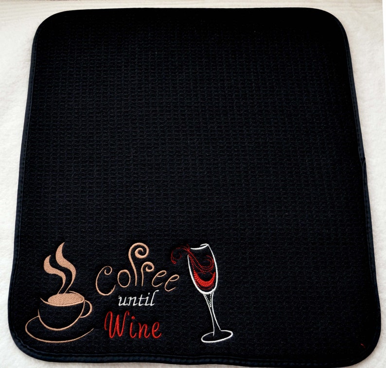 May include: Black kitchen mat with the text "Coffee until Wine" embroidered in white and red. The design includes a coffee cup with steam and a wine glass.