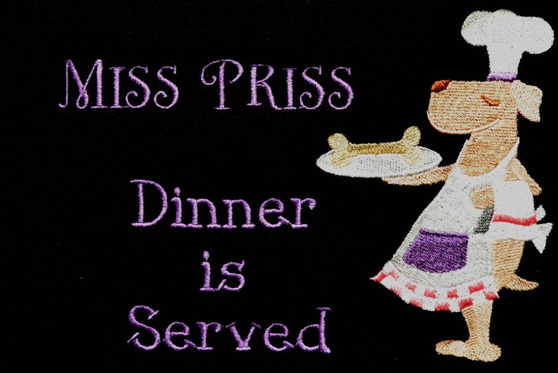 May include: A cartoon dog wearing a chef's hat and apron holds a plate with a bone on it. The text "Miss Priss Dinner is Served" is embroidered in purple on a black background.