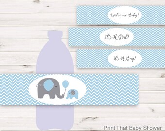 Op de afbeelding: Printbare blauwe en grijze chevron-gepatroneerde baby shower waterfleslabels met een schattig olifantendesign. De labels zeggen "Welkom Baby!" "Het is een meisje!" en "Het is een jongen!"