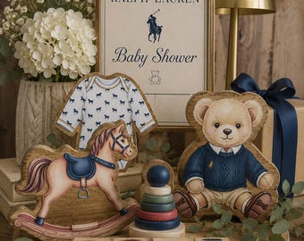 May include: A decorative display featuring a framed Ralph Lauren Baby Shower sign, a wooden rocking horse cutout, a teddy bear cutout wearing a blue sweater, a wooden stacking ring toy, and four wooden blocks spelling BABY in blue and red.