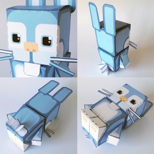 K&ouml;nnte beinhalten: Ein blaues und wei&szlig;es Papierbastel-Kaninchenmodell. Das Kaninchen sitzt mit aufgestellten Ohren. Das Modell besteht aus gefaltetem Papier und hat einen 3D-Effekt.