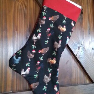 May include: A black Christmas stocking with a red cuff and a pattern of chickens wearing Santa hats.