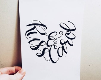 May include: A black and white calligraphy piece in the shape of a heart that says "Kiss & Cuddle".