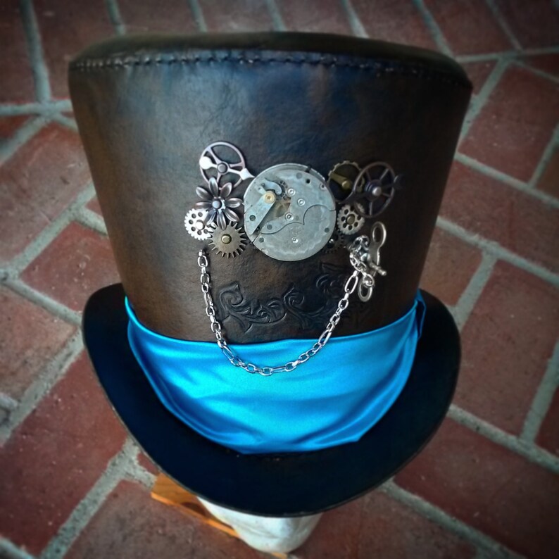 May include: A brown leather top hat with a blue satin band and steampunk-inspired clockwork embellishments.