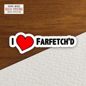 May include: A die-cut sticker featuring a bold red heart symbol positioned between the letter I and the word FARFETCH'D, written in a black, distressed, sans-serif font with a white border, set against a split wood and white background.