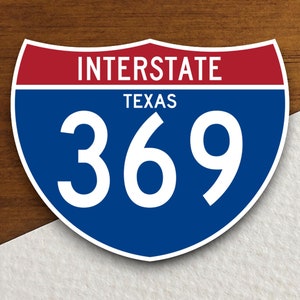 Puede incluir: Una señal de carretera interestatal azul y roja con el número 369 y las palabras "INTERSTATE" y "TEXAS" en blanco.