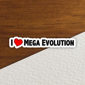 以下が含まれることがあります： 「I ❤️ MEGA EVOLUTION」の黒い文字と赤いハートマークが入った白いステッカー。木製の表面に、白い斜めの背景があります。
