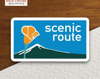 May include: A rectangular sticker with a blue background featuring a white mountain silhouette, a stylized orange California poppy, and the white text "scenic route" in a sans-serif font. The sticker has a white border and rounded corners.