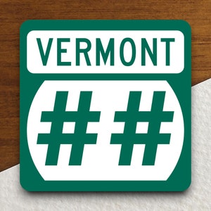 May include: Green and white Vermont road sign with the text "VERMONT" and two hash symbols.