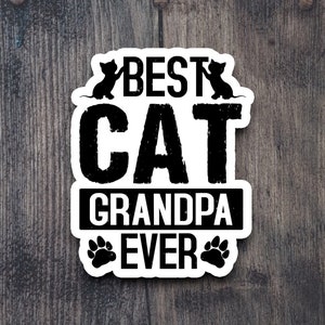 Pu&ograve; includere: Adesivo bianco con testo nero che recita "Best Cat Grandpa Ever". L'adesivo ha due silhouette di gatti neri su entrambi i lati della parola "Best" e due impronte di zampe nere su entrambi i lati della parola "Ever".