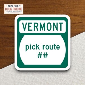 May include: A square sticker with rounded corners featuring a dark green border and a white center. The text VERMONT appears in dark green at the top, while the text pick route ## is centered in dark green within the white area of the sticker.