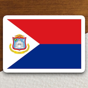 Puede incluir: Una pegatina con la bandera de Sint Maarten. La bandera está dividida en diagonal en azul y rojo con un triángulo blanco en la esquina superior izquierda. El triángulo presenta el escudo de armas de Sint Maarten, que incluye un edificio con un techo amarillo y las palabras "SEMPER PRO GREDIENS" en oro.