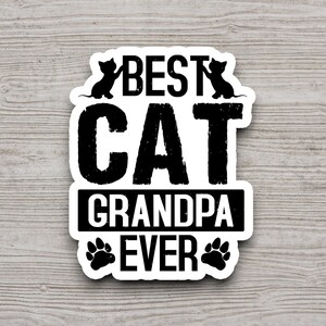 Pu&ograve; includere: Adesivo bianco e nero con il testo "Best Cat Grandpa Ever" con due sagome di gatti e impronte di zampe.