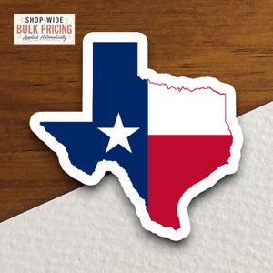 May include: A die-cut sticker shaped like the state of Texas featuring the Texas state flag design. The sticker displays a vertical blue stripe with a single white star, followed by horizontal white and red stripes. It has a white border.