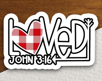 Puede incluir: Una pegatina en blanco y negro con la palabra "Loved" en una fuente estilizada. La "O" de "Loved" es un corazón a cuadros rojo y blanco. La pegatina también incluye el texto "John 3:16" y una flecha.