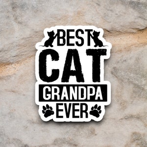 Pu&ograve; includere: Adesivo bianco e nero con il testo "Best Cat Grandpa Ever" con due sagome di gatti e impronte di zampe.