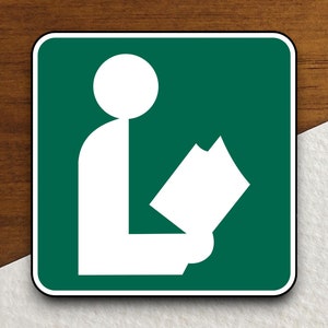 May include: A green square sign with a white silhouette of a person sitting and reading a book. The sign indicates a library.