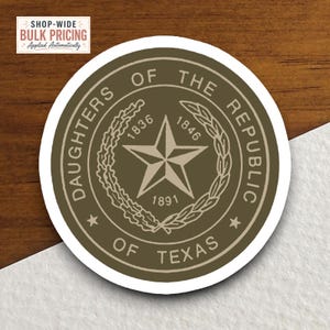 Könnte beinhalten: Ein runder Aufkleber mit dem Emblem der Daughters of the Republic of Texas in Olivgrün und Creme. Das Design zeigt einen zentralen Stern, einen Kranz, die Jahreszahlen 1836, 1846 und 1891 sowie den Text Daughters of the Republic of Texas.