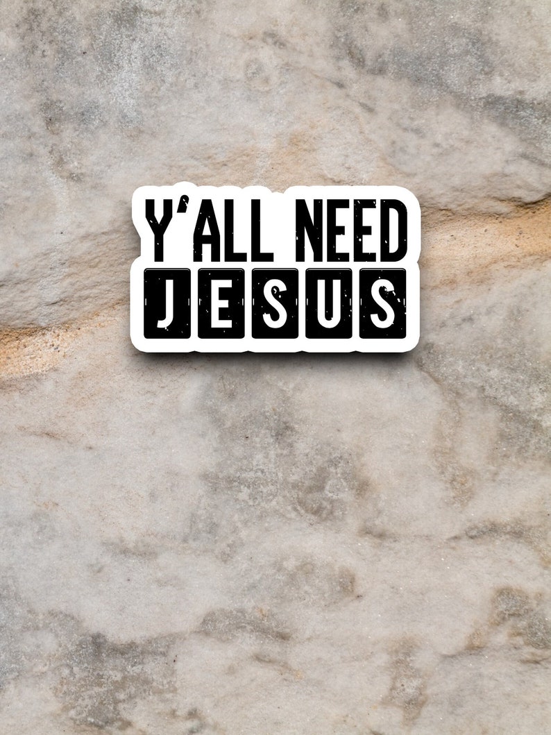 Peut inclure: Un autocollant blanc avec du texte noir qui dit "Y'all need Jesus" sur un fond textur&eacute; gris.