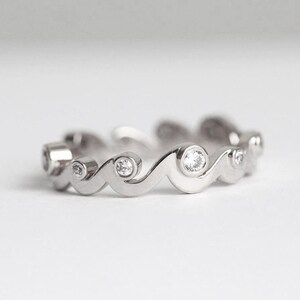 White gold band with diamonds styled as a ocean waves.