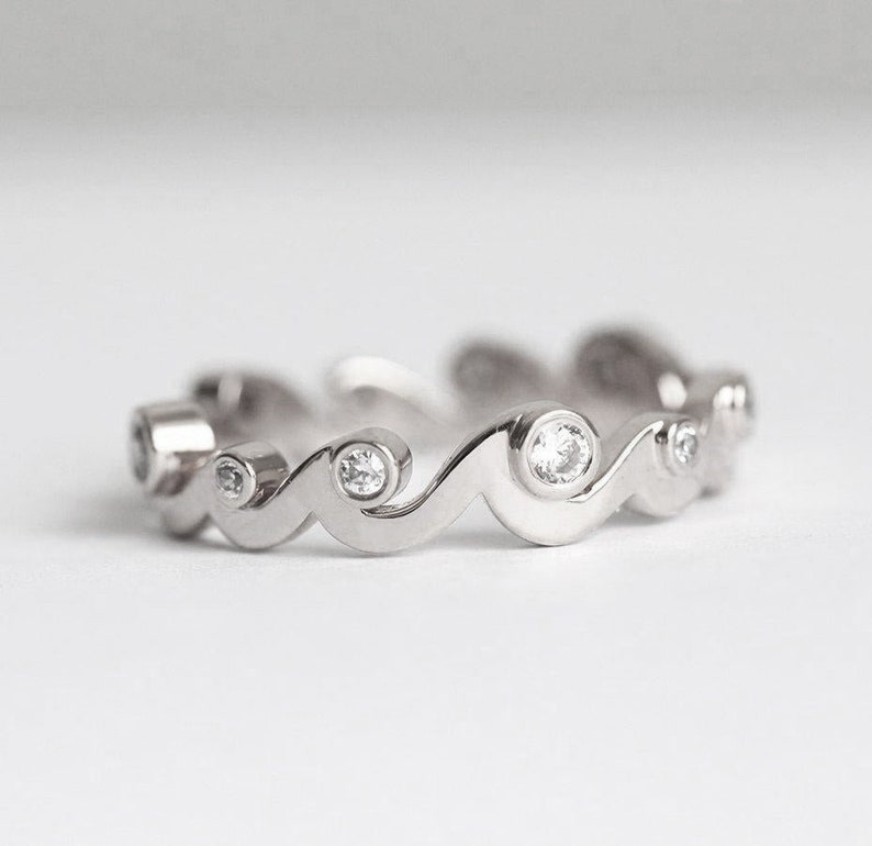 White gold band with diamonds styled as a ocean waves.