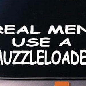 May include: White vinyl decal with the text "Real Men Use A Muzzleloader" on a black background.