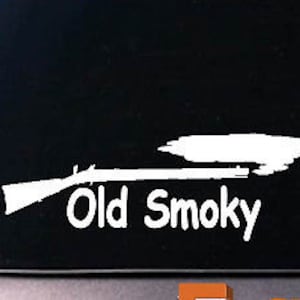 May include: White vinyl decal of a rifle with smoke coming out of the barrel and the text "Old Smoky" underneath.