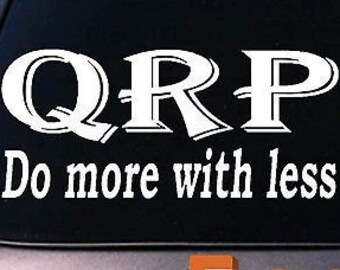 May include: White vinyl decal with the text "QRP Do more with less" on a black background.