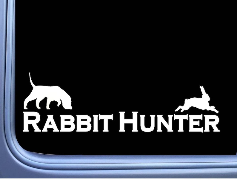 May include: White vinyl decal of a rabbit and a dog with the text "Rabbit Hunter" on a black background.