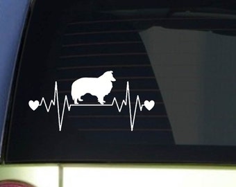 May include: White vinyl decal featuring a silhouette of a Collie dog within a heartbeat design. The design includes two hearts and a line representing a heartbeat, creating a pet-themed graphic.