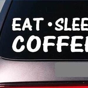 May include: White vinyl decal with the text "Eat - Sleep Coffee" on a black background. The decal is applied to a car window.