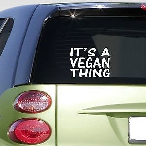 May include: A green car with a white vinyl sticker on the back window that says "It's a Vegan Thing."