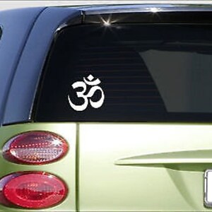 May include: White vinyl sticker of the Om symbol on a green car's rear window.
