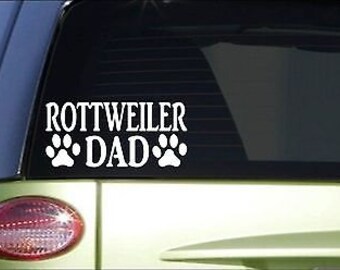 May include: White vinyl decal with the text "Rottweiler Dad" and two paw prints on either side of the word "Dad".