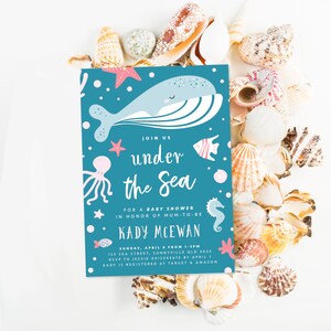 May include: A blue and pink baby shower invitation with an illustration of a whale, octopus, starfish, and a seahorse. The text reads "Join us under the sea for a baby shower in honor of mum-to-be Kady McEwan. Sunday, April 8 from 1-3pm. 123 Sea Street, Sunnyville QLD 3033. RSVP to Jessie 0412345678 by April 1. Kady is registered at Target & Amazon."