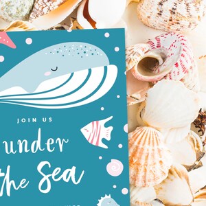 May include: A blue invitation card with a cartoon whale and the text "Join us under the sea". The card is surrounded by seashells.