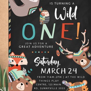 May include: A colorful invitation for a first birthday party with a wild animal theme. The invitation features a black chalkboard background with the text "Is turning a Wild ONE!" and a variety of animals including a fox, bear, deer, and tiger. The invitation also includes the date and time of the party, as well as the location.