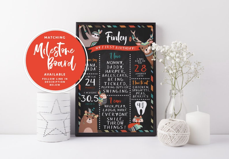 May include: A black chalkboard style milestone poster with a colorful tribal design. The poster features a sloth, a deer, a bear, and a fox. The text on the poster reads "Finley, My First Birthday!" and includes details about the child's birthdate, weight, height, and favorite foods.