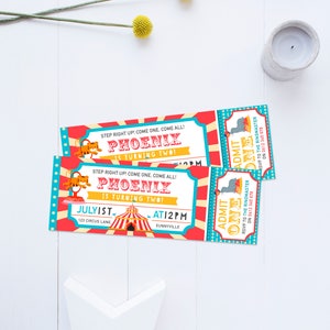 May include: Two red and blue circus ticket invitations with a yellow star on the bottom. The tickets say "Step right up! Come one, come all! Phoenix is turning two!" and "Admit One" with a tiger and elephant illustration. The tickets are for a birthday party on July 1st at 12pm at 123 Circus Lane, Sunnyville.