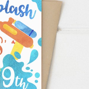 May include: A white card with blue and orange watercolour illustrations of water guns and water splashes. The text on the card reads "Water Splashin'  MAS' 9th".