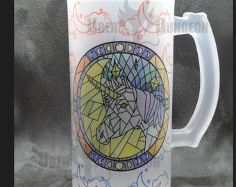May include: A frosted glass beer stein with a colorful stained glass design of a unicorn's head in a circle. The design includes stars, moons, and clouds. The text "Uber Dungeon" is visible on the side of the stein.