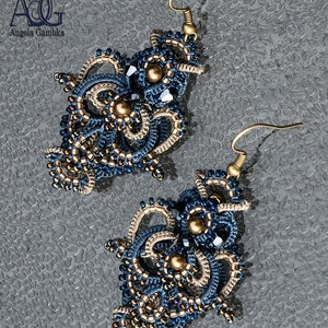 May include: A pair of intricate blue and beige beaded earrings with gold accents. The earrings are in the shape of a flower and have a dangling design.