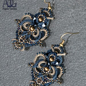May include: A pair of intricate blue and gold beaded earrings with a dangling design. The earrings are made with small beads and have a delicate, intricate look.