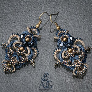 May include: A pair of intricate blue and gold earrings with a beaded design. The earrings are made with small beads and have a delicate, feminine look.
