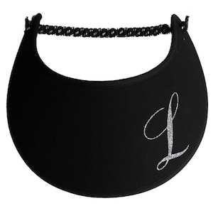 May include: Black visor with a silver glitter letter "L" on the front. The visor has a black elastic band for a secure fit. This accessory is designed to shield the eyes from the sun.