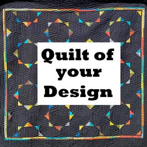 May include: A dark gray quilt with a geometric pattern of hexagons and triangles in shades of orange, yellow, blue, and green. The quilt has the text "Quilt of your Design" in a white rectangle.